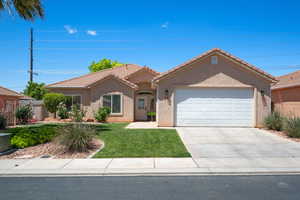 Single story home with a garage, a front lawn, a tile roof, driveway, and stucco siding