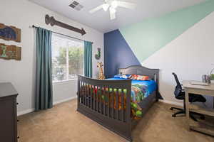 Bedroom with carpet flooring, baseboards, a ceiling fan, and a desk