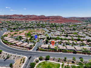 Aerial overview of property's location with a mountainous background and nearby suburban area