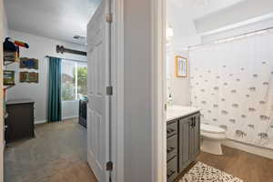 Full bathroom featuring toilet, vanity, a shower with curtain, and baseboards