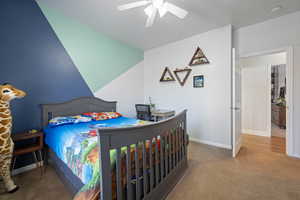 Carpeted bedroom featuring baseboards and ceiling fan