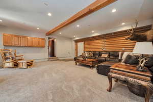 Living area with light colored carpet, recessed lighting, beam ceiling, baseboards, and log walls