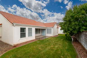 Rear view of property with a chimney, a tiled roof, stucco siding, and a patio area