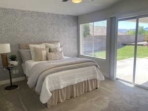 Carpeted bedroom featuring wallpapered walls, access to exterior, baseboards, and a textured ceiling