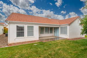 Back of property featuring a patio area, a lawn, central AC unit, and stucco siding