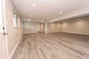 Below grade area with recessed lighting, light wood-style flooring, and baseboards