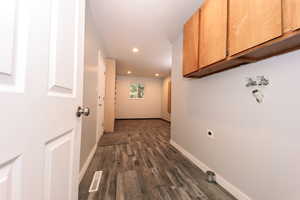 Hallway with dark wood-type flooring, baseboards, and recessed lighting
