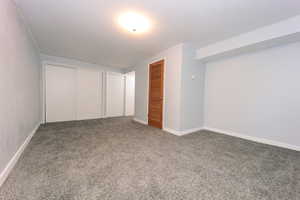Unfurnished bedroom featuring carpet, multiple closets, and baseboards