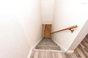 Stairs featuring wood finished floors