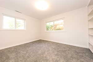 Spare room featuring carpet, baseboards, and ornamental molding