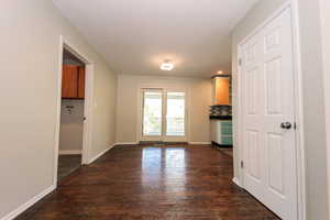 Unfurnished dining area featuring dark wood-style flooring, baseboards, and recessed lighting
