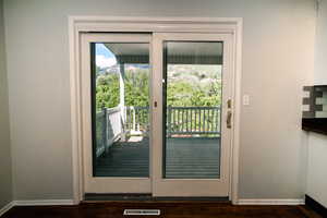 Doorway to outside with baseboards and dark wood-style flooring