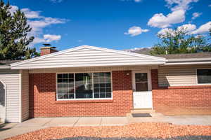 View of front of home with a chimney and brick siding