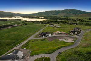 Aerial view of property and surrounding area featuring a mountainous background and rural landscape