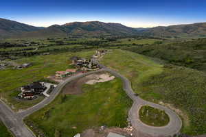 Aerial overview of property's location with a mountain backdrop and rural landscape