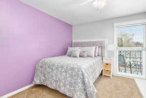 Carpeted bedroom featuring ceiling fan and baseboards