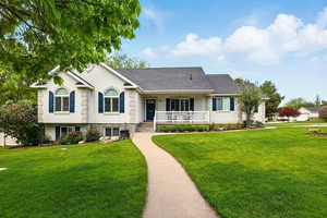 View of front of house featuring a porch, a front yard, and roof with shingles
