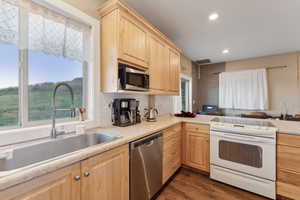 Roper Pole Barn | Conditioned Use |Kitchen featuring appliances with stainless steel finishes, light brown cabinets, a sink, healthy amount of natural light, and recessed lighting