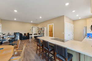 Roper Pole Barn | Conditioned Use |Kitchen featuring black electric stovetop, recessed lighting, a peninsula, dark wood-style flooring, and a breakfast bar area