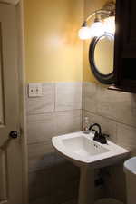 Bathroom with tile walls and toilet
