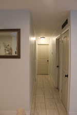 Corridor featuring baseboards and light tile patterned floors