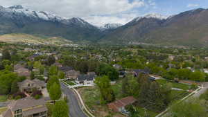 Aerial view of property and surrounding area with a mountain backdrop and nearby suburban area