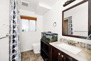 Full bath featuring toilet, baseboards, vanity, and a shower with curtain