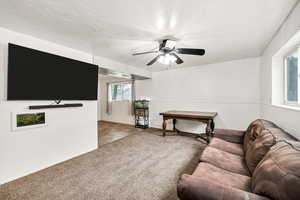 Carpeted living area with ceiling fan