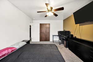 Bedroom featuring carpet flooring, a desk, and a ceiling fan