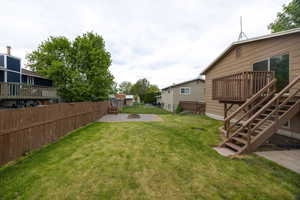 View of yard featuring an outdoor fire pit, a wooden deck, and stairway