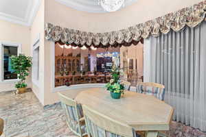 Dining space featuring crown molding and a chandelier
