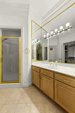 Bathroom featuring ornamental molding, a shower stall, vanity, and tile patterned floors