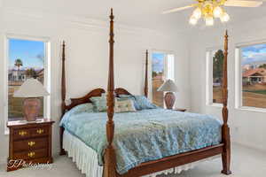Carpeted bedroom featuring baseboards, ornamental molding, and a ceiling fan