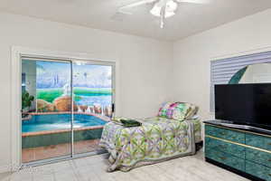 Tiled bedroom featuring access to outside and ceiling fan