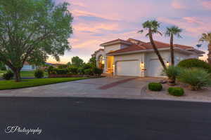 Mediterranean / spanish-style home featuring an attached garage, concrete driveway, stucco siding, and a tiled roof