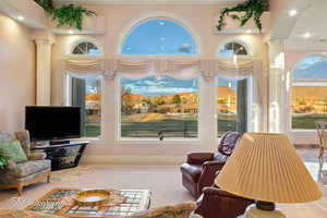 Living area with ornate columns, recessed lighting, and crown molding