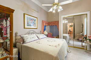 Bedroom featuring carpet floors, ornamental molding, a closet, and ceiling fan