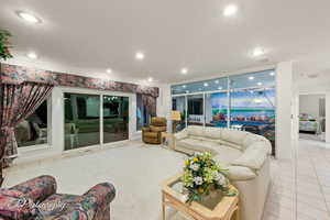Living area with crown molding, tile patterned flooring, and recessed lighting
