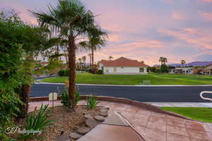 Patio terrace at dusk featuring a yard and a residential view