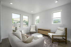 Living room with baseboards, wood finished floors, and recessed lighting