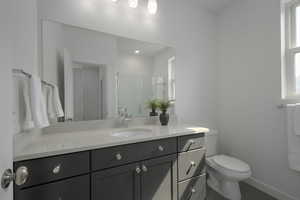 Bathroom with toilet, vanity, baseboards, and tile patterned floors