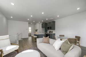 Living area featuring dark wood-type flooring, recessed lighting, and baseboards