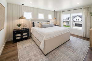 Bedroom with wood finished floors, baseboards, multiple windows, and recessed lighting