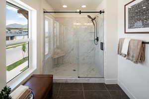 Full bathroom featuring plenty of natural light, a mountain view, a marble finish shower, baseboards, and recessed lighting
