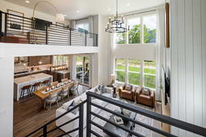 Living area with wood finished floors, a chandelier, a towering ceiling, and recessed lighting