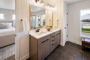 Bathroom with ensuite bath, baseboards, double vanity, and marble finish floors