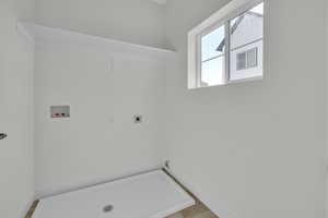 Laundry area featuring electric dryer hookup, hookup for a washing machine, and baseboards