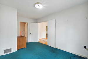 Unfurnished bedroom with carpet flooring and baseboards