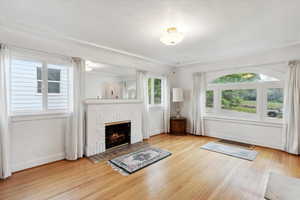 Unfurnished living room with baseboards, wood finished floors, and a fireplace