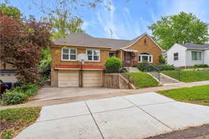 Bungalow with brick siding, driveway, a garage, and a shingled roof